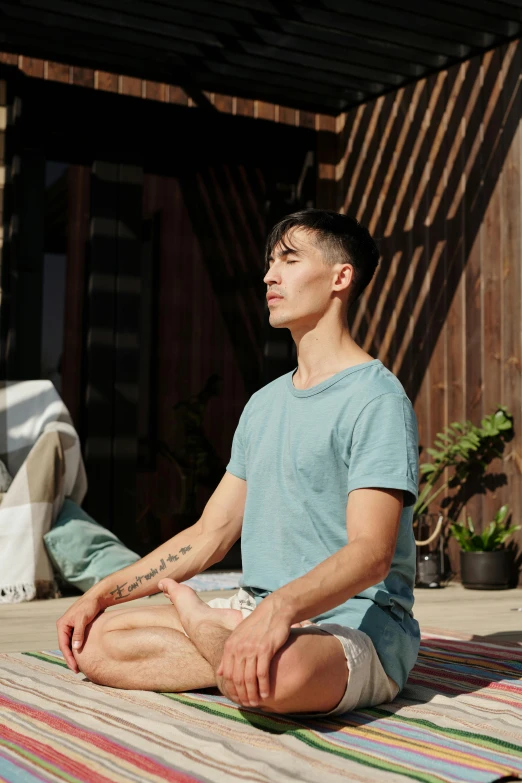 a man sitting in the middle of a yoga pose, federation clothing, curated collections, daytime, calm