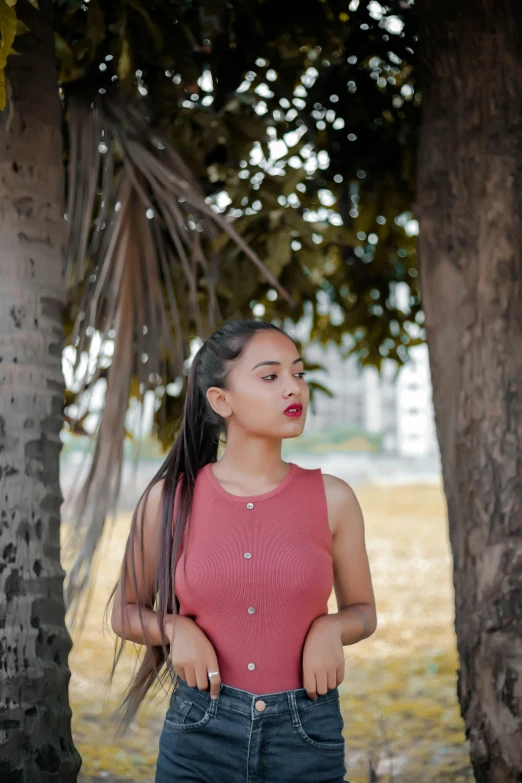 a woman standing in front of some trees, by reyna rochin, pexels contest winner, 2 4 year old female model, long braided hair pulled back, lipstick, light-brown skin