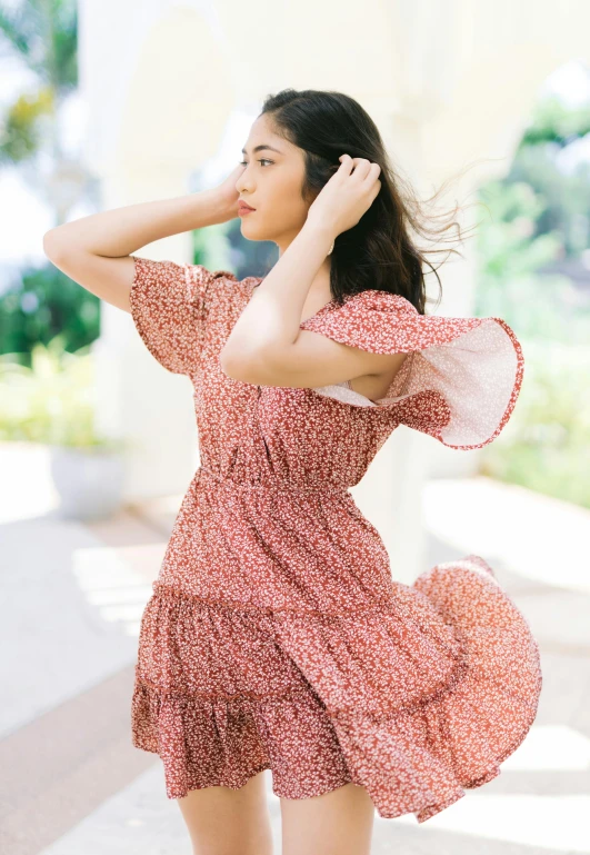 a woman in a pink dress walking down a sidewalk, red floral dress, twirls, malaysian, profile image