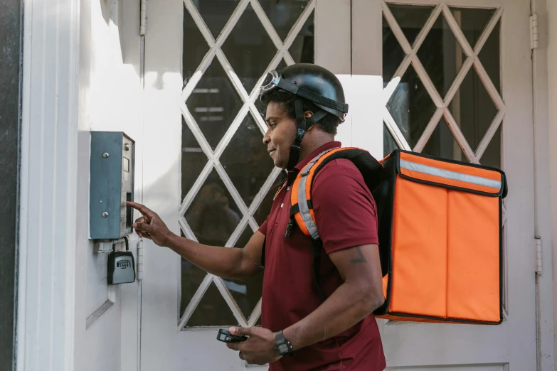 a man that is standing in front of a door, delivering parsel box, helmet on, profile image, maintenance photo