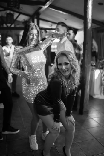 a couple of women standing next to each other on a dance floor, a black and white photo, pexels, happening, 🐿🍸🍋, dasha taran, wearing a sparkling dress, various posed