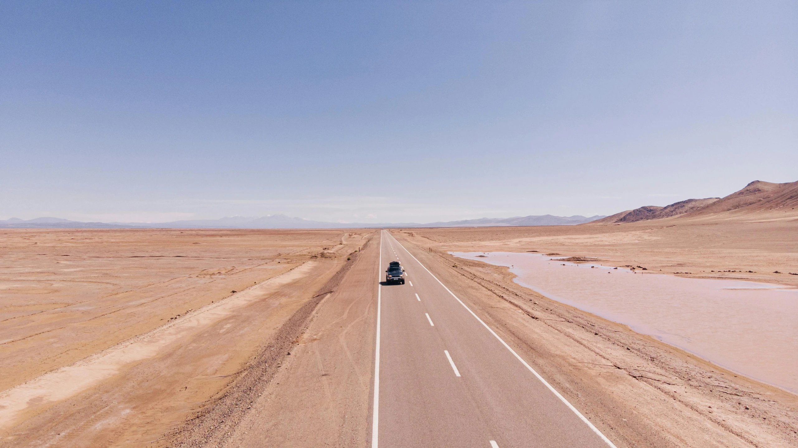 a car driving down the middle of a desert road, pexels contest winner, chile, avatar image, background image, runway