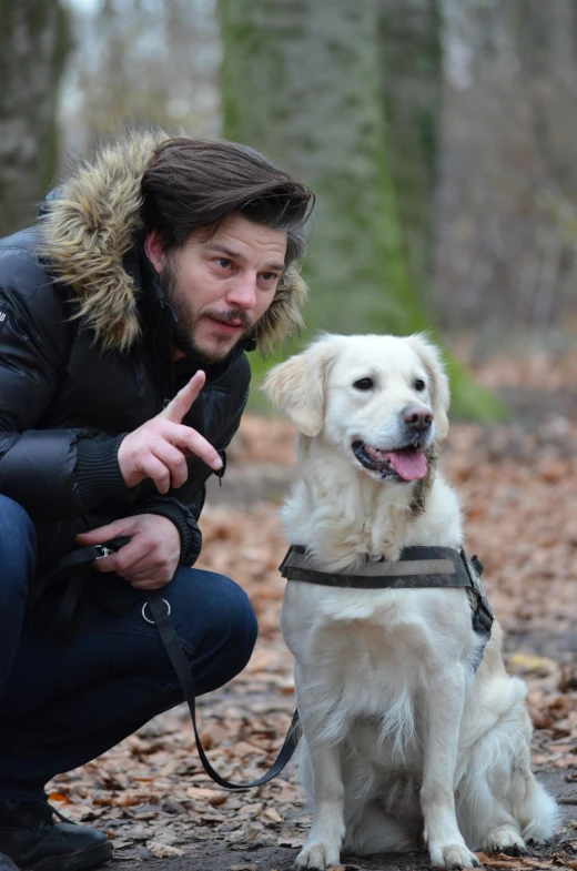 a man kneeling down next to a white dog, by Jan Tengnagel, shutterstock, andrew garfield, mark edward fischbach, tv show still, belgium