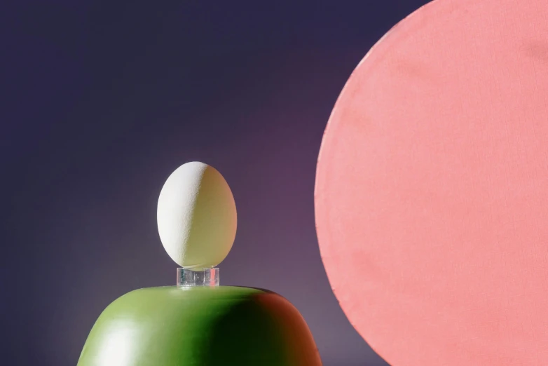 a white egg sitting on top of a green bell, an abstract sculpture, inspired by Herbert Bayer, pink studio lighting, lush and colorful eclipse, offering the viewer a pill, product shot