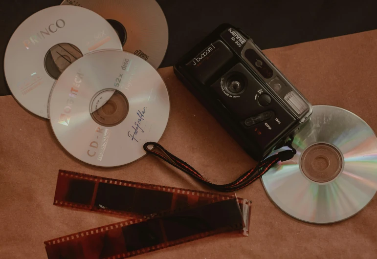 a couple of cds sitting on top of a table, a polaroid photo, pexels contest winner, video art, cinematic camera, ( ( theatrical ) ), film artifacts, cinematic movie image