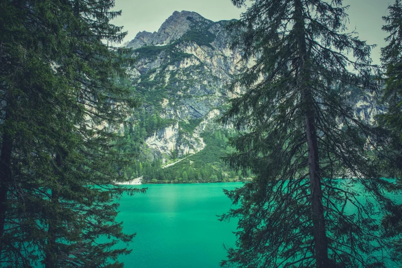 a lake surrounded by pine trees with a mountain in the background, pexels contest winner, visual art, cyan and green, multiple stories, fine art print, green water