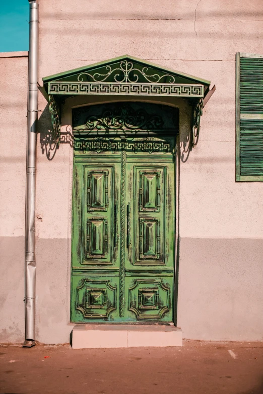 a green door sitting on the side of a building, inspired by Gustave Boulanger, buenos aires, bizzaro, brown, exterior