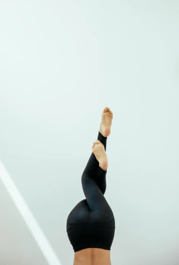 a woman doing a handstand pose on a yoga mat, unsplash, arabesque, wearing black tight clothing, mid view from below her feet, 15081959 21121991 01012000 4k, medium shoot