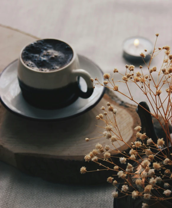 a cup of coffee sitting on top of a wooden tray, a still life, by Robbie Trevino, trending on unsplash, romanticism, dried flowers, dark and beige atmosphere, brown and cream color scheme, multiple stories