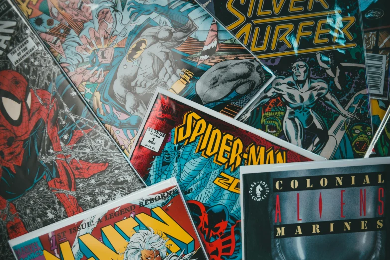 a pile of comic books sitting on top of a table, a comic book panel, inspired by Jim Lee, pexels contest winner, silver, video game cover art, 1980s photo, super heroes