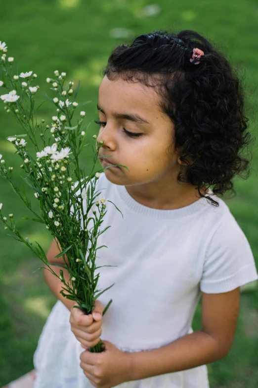 a little girl holding a bunch of flowers, by Ellen Gallagher, pexels contest winner, symbolism, fragrant plants, white, ameera al-taweel, made of wildflowers