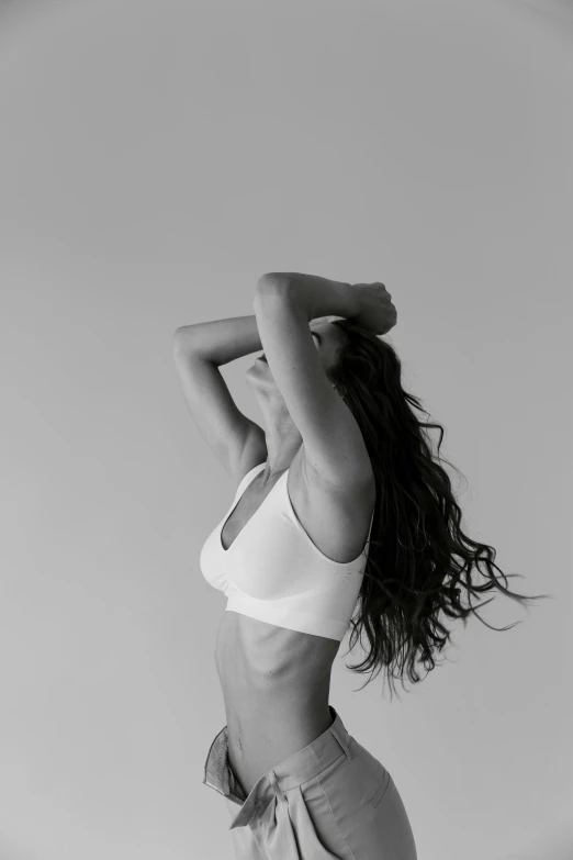 a black and white photo of a woman in shorts, pexels contest winner, white bra, the woman has long dark hair, dance meditation, with a white background