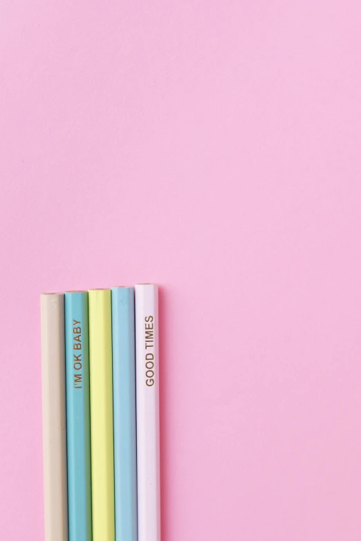 a stack of books sitting on top of a pink surface, colored pencils, good vibes, pastel blue, product shot