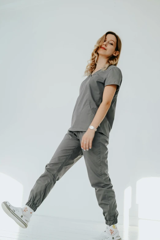 a woman standing in the middle of a white room, in gunmetal grey, nurse scrubs, wearing cargo pants, jill stingray