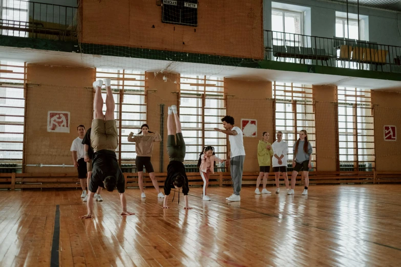 a group of people standing on top of a wooden floor, unsplash, arabesque, soviet style, local gym, private school, square