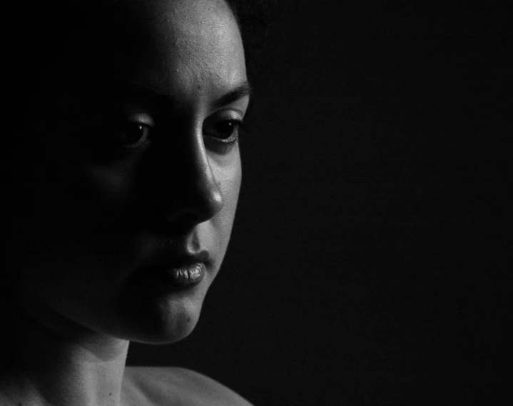 a black and white photo of a woman's face, a black and white photo, by Dimitre Manassiev Mehandjiysky, pexels contest winner, dramatic lowkey studio lighting, chiaroscuro!!, medium format. soft light, woman with black hair