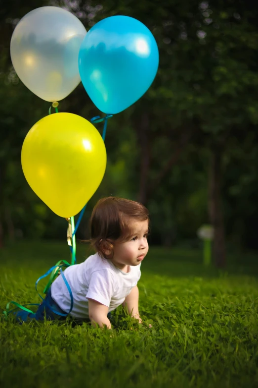 a baby laying in the grass with a bunch of balloons, by Lilia Alvarado, shutterstock contest winner, at a birthday party, looking to his side, walking towards camera, yellow and blue ribbons