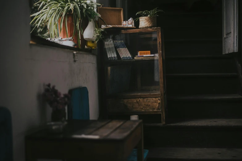 a bookshelf filled with lots of books next to a window, a still life, pexels contest winner, happening, small hipster coffee shop, staircase, background image, cinematic medium shot