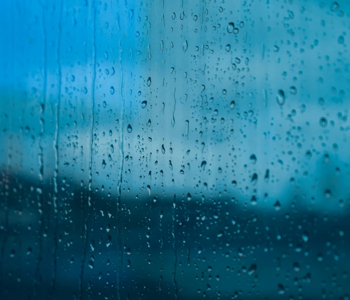 a close up of water droplets on a window, inspired by Elsa Bleda, unsplash, visual art, wrapped blue background, background image, rainy evening, thumbnail