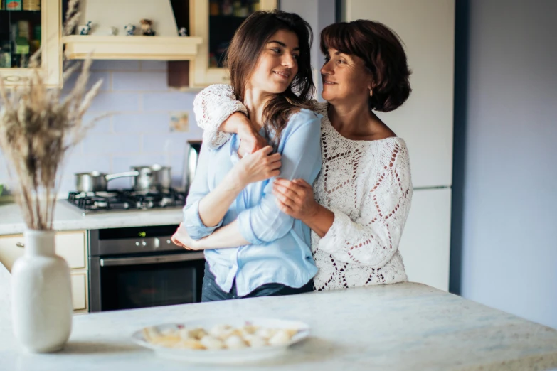two women standing next to each other in a kitchen, by Julia Pishtar, pexels contest winner, sweet hugs, brunette, family dinner, lightly dressed