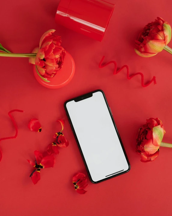 a phone sitting on top of a red table next to flowers, product image, bright red lipstick, dark. no text, thumbnail