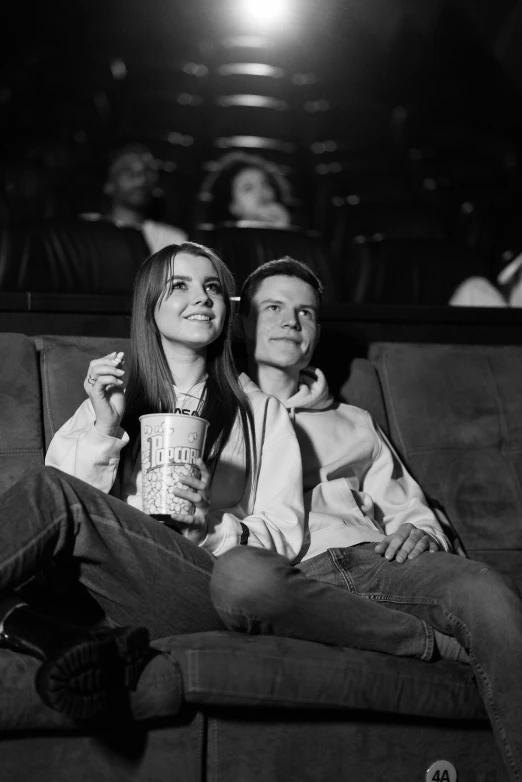 a couple of people that are sitting on a couch, a black and white photo, pexels, renaissance, sitting in a movie theater, dafne keen, 🌸 🌼 💮, happy couple