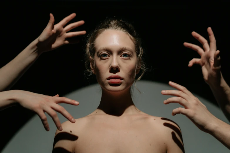 a woman standing in front of a mirror with her hands in the air, inspired by Vanessa Beecroft, pexels contest winner, hyperrealism, in front of a black background, patricia piccinini, sydney sweeney, projection mapping