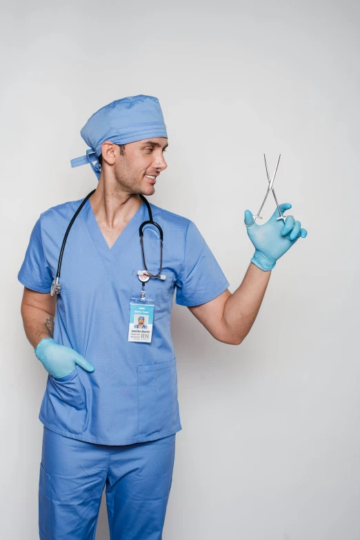 a man in scrubs holding a pair of scissors, trending on reddit, implants, official product photo, (doctor), highly capsuled