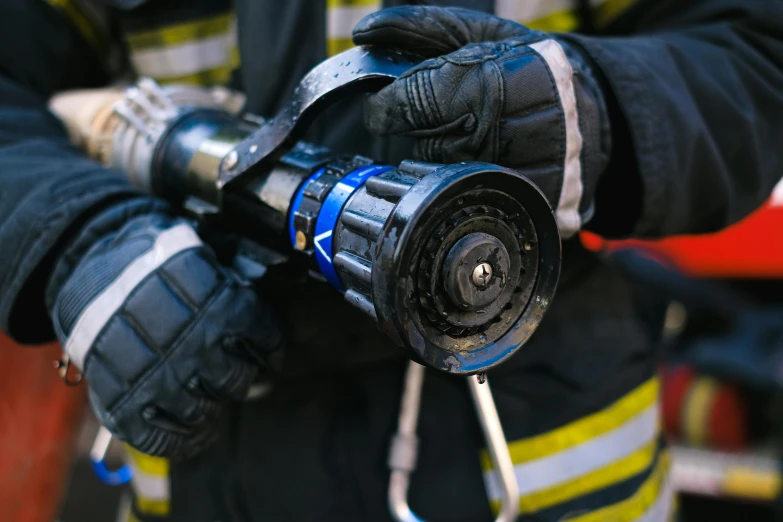 a close up of a fireman holding a hose, a picture, pexels, hurufiyya, holding an activated lightsaber, holding a bell, professional photo, high-res