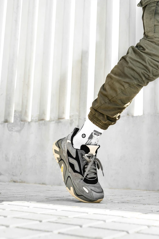 a man riding a skateboard down a sidewalk, an album cover, inspired by Salomon Koninck, trending on pexels, futuristic balenciaga sneakers, grey and silver, profile image, army