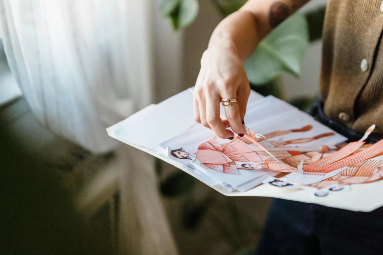 a close up of a person holding a piece of paper, a picture, by Julia Pishtar, magazines, fashion designer, fashion design, on a canva