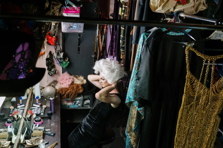 a woman that is standing in front of a mirror, by Gwen Barnard, trending on pexels, maximalism, exiting from a wardrobe, burlesque psychobilly, sitting on a store shelf, older woman