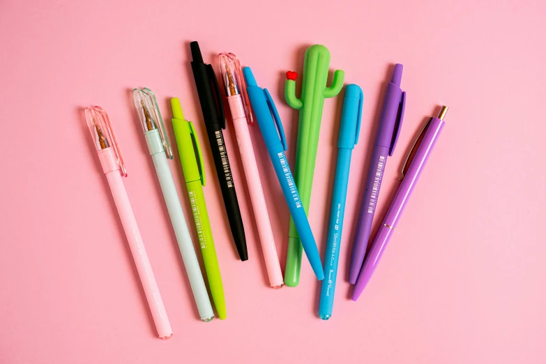 a group of pens sitting next to each other on a pink surface, full product shot, ((neon colors)), detailed product image, mint