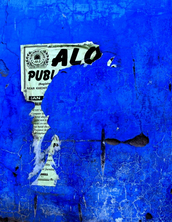 a blue wall with a sign on it, an album cover, by Alejandro Obregón, flickr, spectacular quality torn paper, pub, yolo, alp