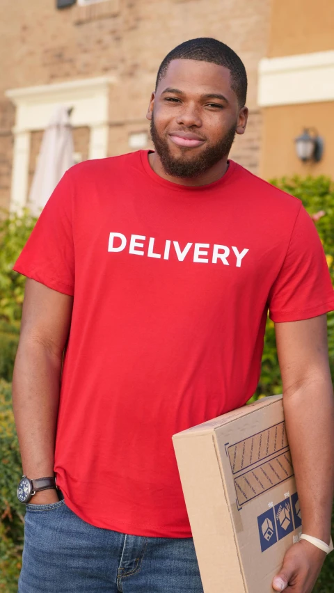 a man in a red shirt holding a box, logo for lunch delivery, wearing a t-shirt, outfit photograph, digital image