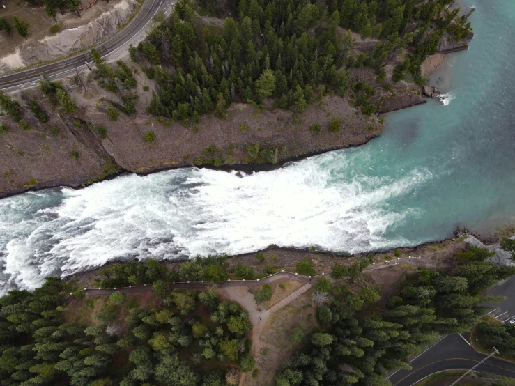 an aerial view of a river running through a forest, by Doug Wildey, pexels contest winner, hurufiyya, banff national park, wall of water either side, video still, whirlpool