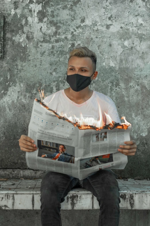 a man sitting on a bench reading a newspaper, an album cover, by Adam Marczyński, trending on pexels, renaissance, all face covered with a fire, standing in fire, non-binary, the mask is broken