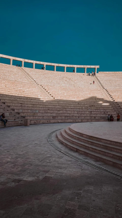 a man riding a skateboard up the side of a ramp, by Ibrahim Kodra, unsplash contest winner, brutalism, ancient persian city, photo of a big theaterstage, square, ( ( theatrical ) )