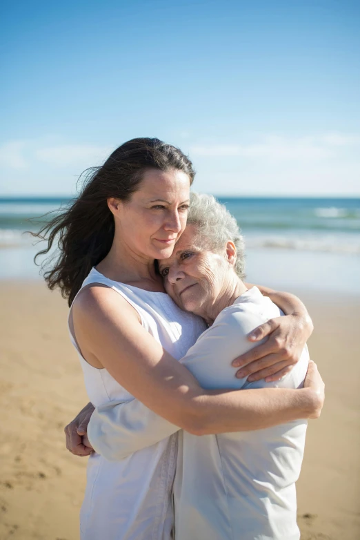 a woman hugging a man on the beach, a portrait, by Elizabeth Durack, unsplash, renaissance, older woman, woman holding another woman, sunny environment, 15081959 21121991 01012000 4k