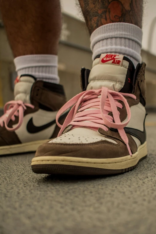 a close up of a pair of sneakers with pink laces, an album cover, inspired by Jordan Grimmer, unsplash, renaissance, wearing a brown, off white, pink iconic character, jinx