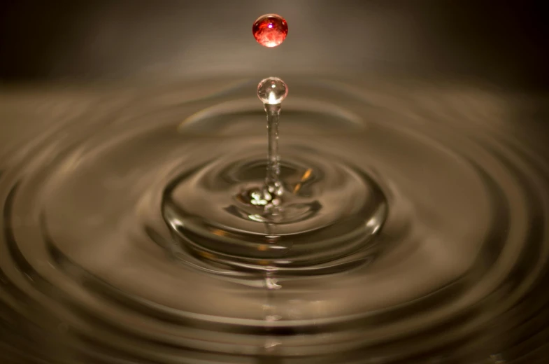 a drop of water falling into a pool of water, by Jan Rustem, rubies, fan favorite, dmt ripples, plain background