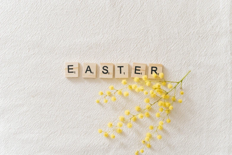 a bunch of yellow flowers sitting on top of a white surface, a picture, by Ellen Gallagher, trending on unsplash, easter, letters, holy themed, square enix