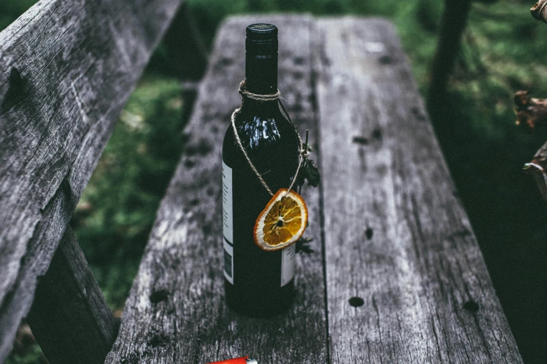 a bottle of wine sitting on top of a wooden bench, pexels contest winner, coca cola bottle, miscellaneous objects, listing image, outdoor photo