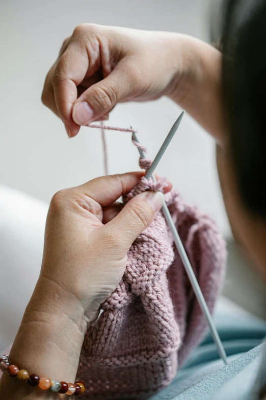 a close up of a person knitting a sweater, inspired by Ruth Jên, unsplash, process art, promo image, sculpting, made of fabric, blushing