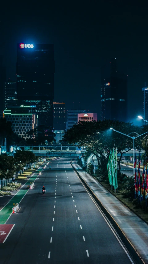 an empty street in the middle of a city at night, by Adam Rex, unsplash contest winner, jakarta, tech city in the background, square, outdoors tropical cityscape