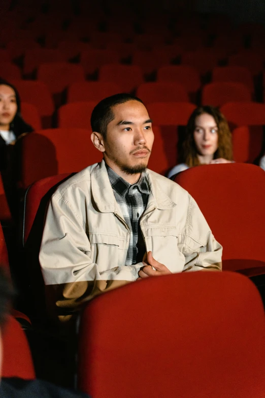 a group of people sitting in a movie theater, inspired by Fei Danxu, trending on pexels, hyperrealism, handsome man, cinestill 800t 35mm eastmancolor, [ theatrical ]