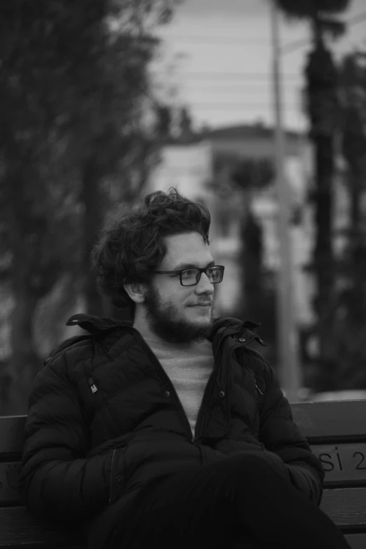 a black and white photo of a man sitting on a bench, by Ahmed Yacoubi, seth aaron rogen, ((portrait)), young handsome pale roma, lo fi