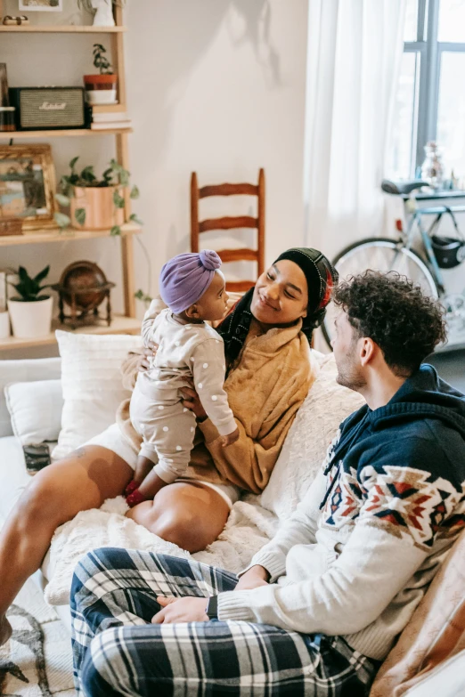 a group of people sitting on top of a couch, with a kid, maternity feeling, airbnb, wholesome