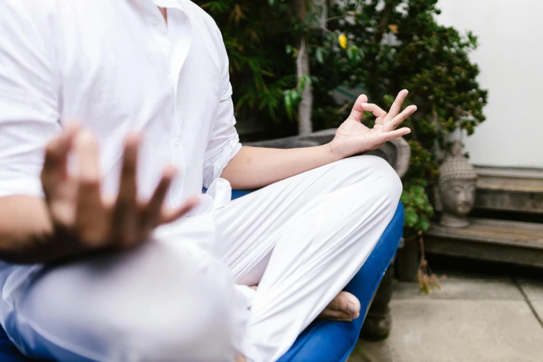 a man sitting in a chair with his hands in the air, unsplash, paradise garden massage, wearing white robes, anjali mudra, sit on a bench