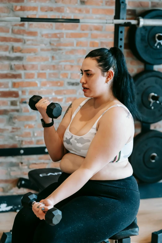 a woman sitting on top of a bench in a gym, pexels contest winner, hurufiyya, plus size, lifting weights, profile image, mai anh tran